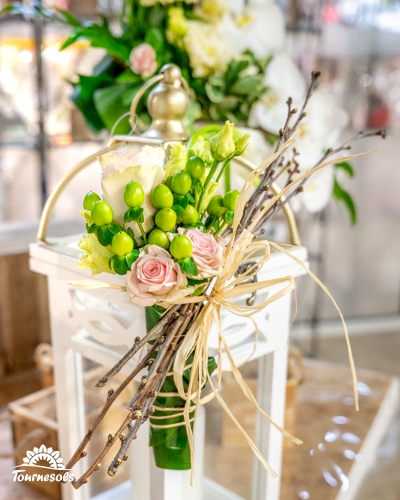 Composition florale de mariage avec roses pâles et baies vertes présentée au salon du mariage de Charleroi